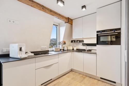 a kitchen with white cabinets and a window at Modern Elegance in historical City Center in Trier