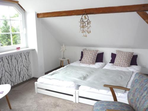 1 dormitorio con cama blanca y lámpara de araña en Ferienwohnung Hinz, en Ellingstedt