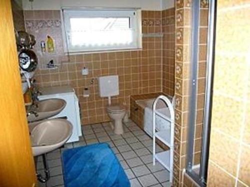 a bathroom with two sinks and a toilet and a window at Appartment 1070 im EG in Tossens in Butjadingen OT Tossens