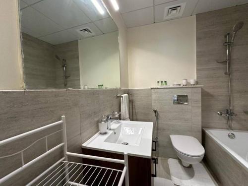ein Badezimmer mit einem Waschbecken, einem WC und einer Badewanne in der Unterkunft Layover in the Green City 203O3 in Al Qurayyah
