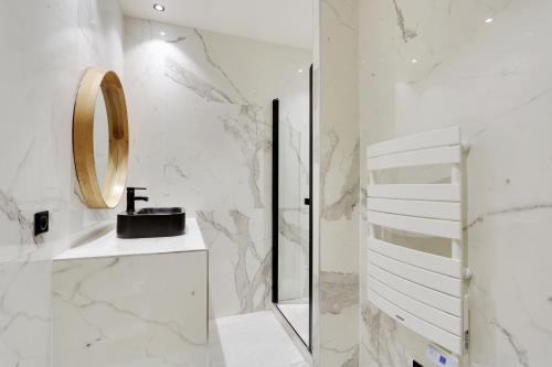 Baño blanco con lavabo y espejo en Pick A Flat's Apartment in Place Vendôme/Tuileries - Rue Saint-Honoré, en París