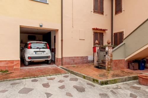 a white car parked in a garage next to a building at Casa Zito in San Giuliano Terme