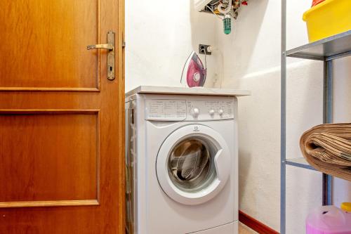 a washing machine in a small room with a door at Casa Zito in San Giuliano Terme