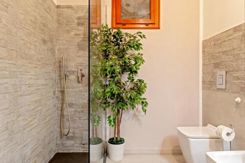 a bathroom with two potted plants in a shower at Casa Zito in San Giuliano Terme
