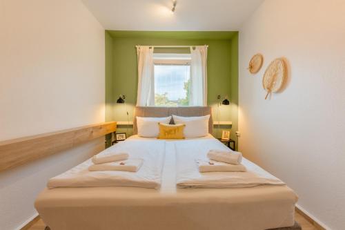 - une chambre avec un grand lit et une fenêtre dans l'établissement Stay Awesome - Urban Jungle Apartment Zentral, Wilhelmshöhe, à Cassel