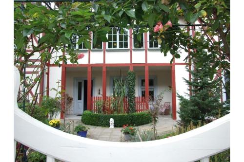 une maison blanche avec un chien blanc devant elle dans l'établissement Villa Gundula nur 600m bis zum Ostseestrand, à Zinnowitz