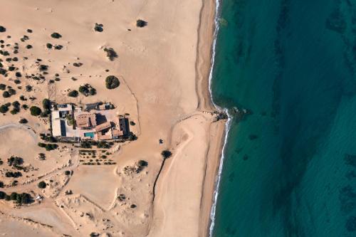 an aerial view of a house on the beach at Hotel Le Dune Piscinas in Ingurtosu
