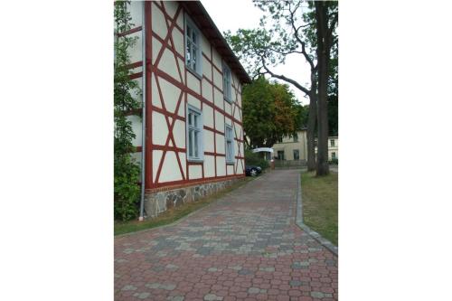 un bâtiment rouge et blanc avec un trottoir en briques dans l'établissement Villa Gundula nur 600m bis zum Ostseestrand, à Zinnowitz