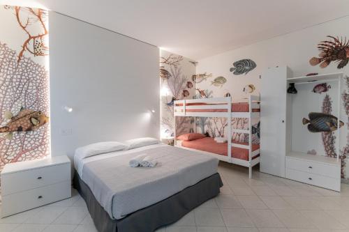 a bedroom with a bed and two bunk beds at Camping Villaggio Calypso in Cupra Marittima