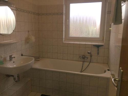 bagno con vasca, lavandino e finestra di Haus Bergglück a Hückelhoven
