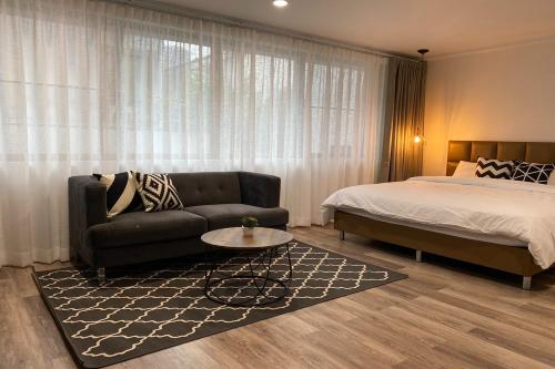 a bedroom with a bed and a couch and a table at Cordia Residence Saladaeng in Bangkok