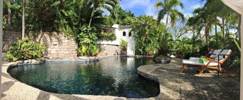 einen Pool in einem Hof mit einem Haus in der Unterkunft Smuggler's Nest - Exotic & romantic villa villa in Cap Estate