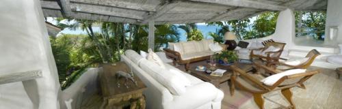 ein Wohnzimmer mit einem weißen Sofa und Stühlen in der Unterkunft Smuggler's Nest - Exotic & romantic villa villa in Cap Estate