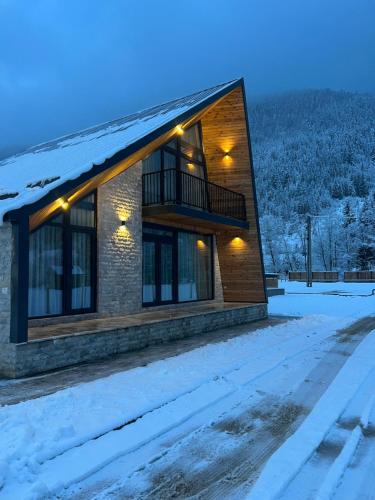 Una casa en la nieve por la noche en Elviu Guesthouse, en Lacu Roșu