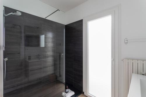 La salle de bains est pourvue d'une douche avec du carrelage noir. dans l'établissement Le Petit Malouin - Appartement proche plage, à Saint-Malo