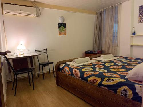 Hello Fox GuestHouse في تبليسي: غرفة نوم بسرير ومكتب وطاولة
