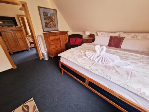 a bedroom with a large bed and a dresser at Hotel Elisabeth Ilse in Braunlage