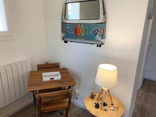 une chambre avec une table avec une lampe et une camionnette sur le mur dans l'établissement Saint Georges de Didonne - AGREABLE APPARTEMENT RENOVE à proximité de la mer, à Saint-Georges-de-Didonne