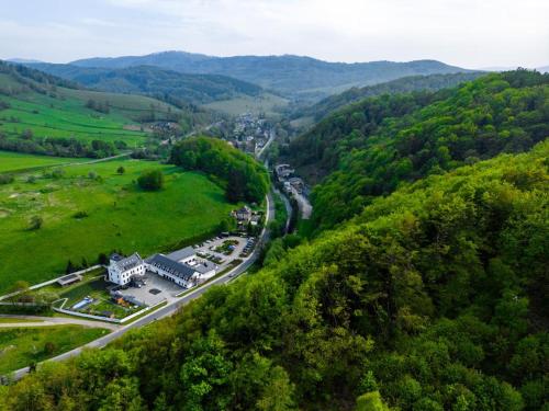 an aerial view of a town in a valley with a road at Hotel Pałac Jugowice in Wałbrzych