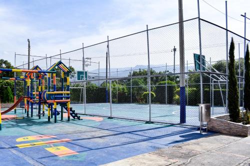 a tennis court with a playground at 3 Habitaciones Amplias y Confortables, Casa Almonacid Cúcuta in Cúcuta