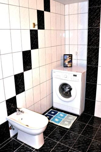 a bathroom with a washing machine and a toilet at Villa Leonidas just enjoy your holidays in Pitsidia
