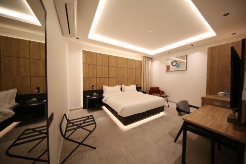 a hotel room with a bed and a desk at أجنحة درة Dorra Suites in Riyadh