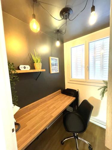 a room with a wooden table and a chair at LAppart de Gauche Confort en ville avec parking privé in Le Creusot