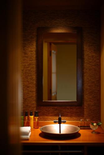 a sink in a bathroom with a mirror at Futari Shizuka in Komagane