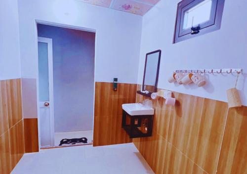 een badkamer met een toilet, een wastafel en een spiegel bij Homestay Nguyễn Hưng in Tân Tạo