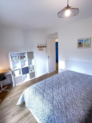 a white bedroom with a bed and a desk at LAppart de Gauche Confort en ville avec parking privé in Le Creusot