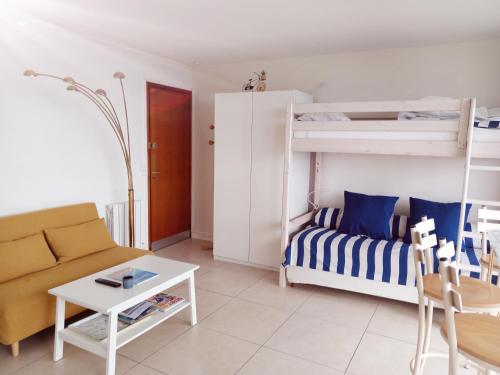 a living room with a bunk bed and a couch at T1 bis neuf avec petite chambre à 150m de la plage in La Baule