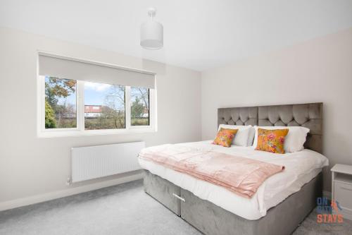 1 dormitorio con 1 cama grande y ventana en OnSiteStays New Large modern 4 bed, Parking, Wifi, 2 x Bathroom en Orpington