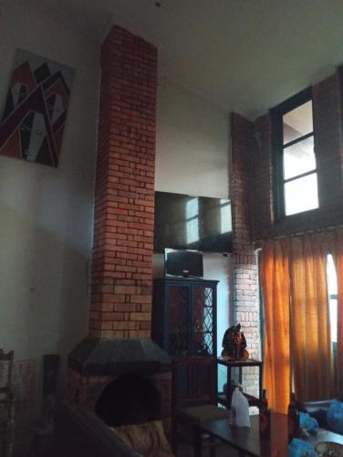 sala de estar con chimenea de ladrillo en Hotel Mountain Ridge en Bandipur