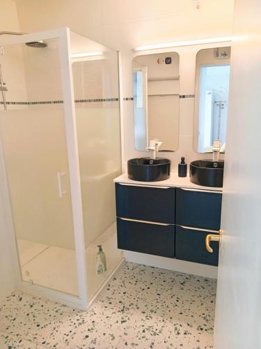 une salle de bain avec deux lavabos et une douche dans l'établissement T1 bis neuf avec petite chambre à 150m de la plage, à La Baule