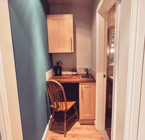 a small kitchen with a wooden table and a chair at The Hanmer Arms in Hanmer