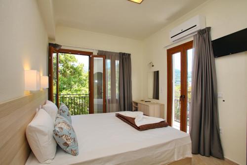 a bedroom with a bed and a balcony at Aktaion Guest Rooms in Skopelos Town