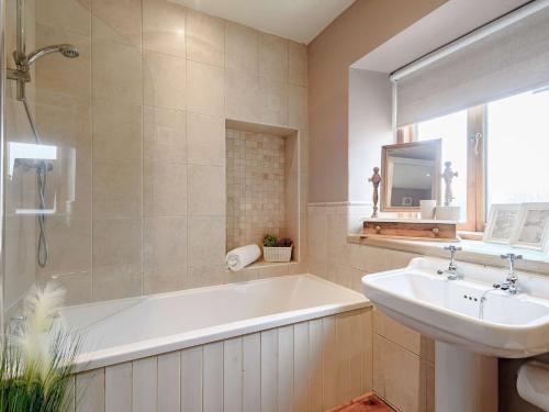 a bathroom with a tub and a sink and a bath tub at 3 Bed in Hartington 54215 in Hartington