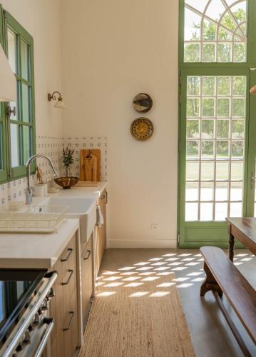 une cuisine avec un évier et une grande fenêtre dans l'établissement Luxueuse Villa avec piscine, à Le Temple