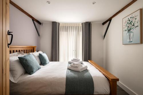 a bedroom with a bed with towels on it at The Cart House in Southampton