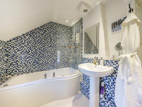 un bagno con vasca bianca, lavandino e vasca tubermott di 1 Bed in Evesham 55177 a Bretforton