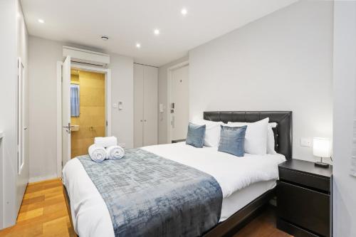 a bedroom with a large bed with two towels at Private Studio Flat in London