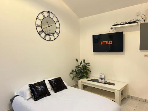 Cette chambre comprend un lit et une horloge murale. dans l'établissement Le Mollien, à Calais