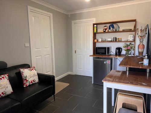 a living room with a couch and a kitchen at Apollo Stay in Apollo Bay