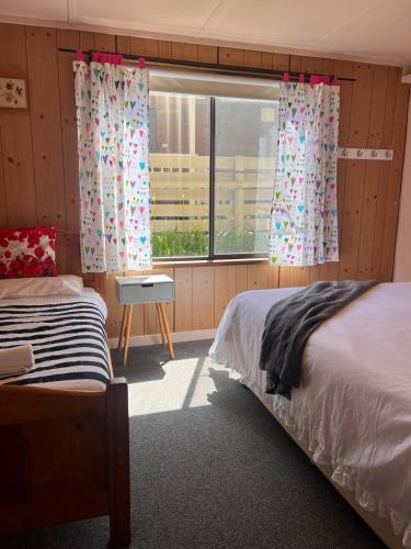 a bedroom with two beds and a window at Apollo Stay in Apollo Bay
