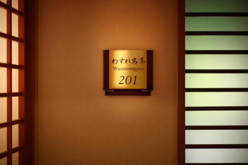 a sign on a wall with aiversary sign on it at Futari Shizuka in Komagane