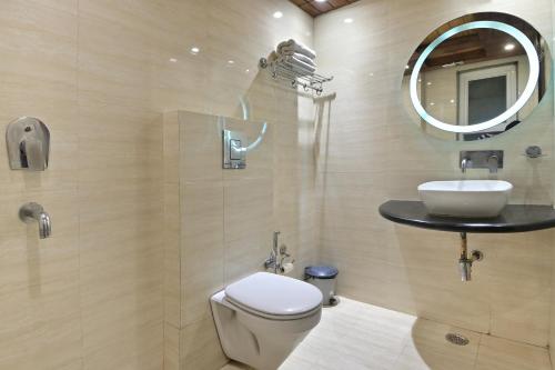 a bathroom with a sink and a toilet and a mirror at Hotel Hari Piorko Inn - New Delhi Railway Station in New Delhi