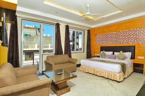 a bedroom with a bed and a living room with a couch at Hotel Hari Piorko Inn - New Delhi Railway Station in New Delhi