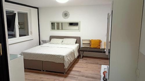 a small bedroom with a bed and a chair at Apartma Vas in Maribor
