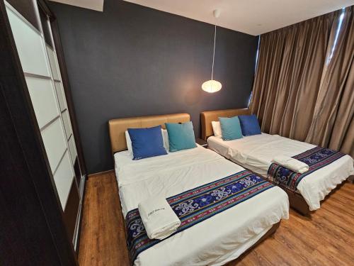 Vivacity Jazz Suites 2 New Cozy Home LV8 في كوتشينغ: غرفة بسريرين مع وسائد زرقاء