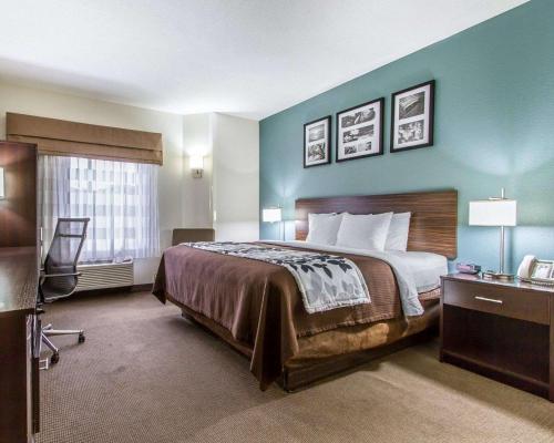 ein Hotelzimmer mit einem Bett und einem Fenster in der Unterkunft Sleep Inn Scott-Lafayette West in Scott